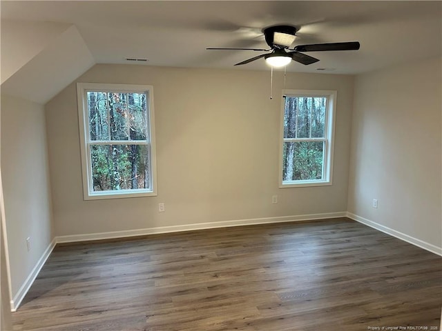 empty room featuring ceiling fan, lofted ceiling, and dark hardwood / wood-style floors