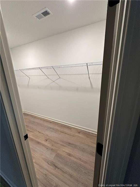 spacious closet with hardwood / wood-style floors