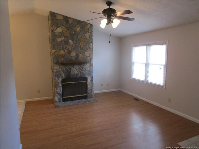 unfurnished living room with a fireplace, ceiling fan, and wood-type flooring