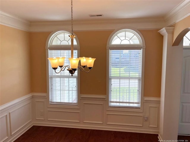 entryway with ornate columns, crown molding, dark wood-type flooring, and plenty of natural light