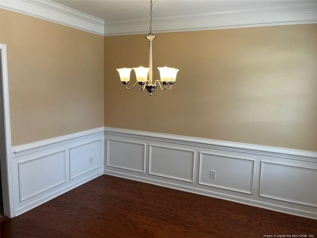 empty room with ornamental molding, an inviting chandelier, and dark hardwood / wood-style flooring