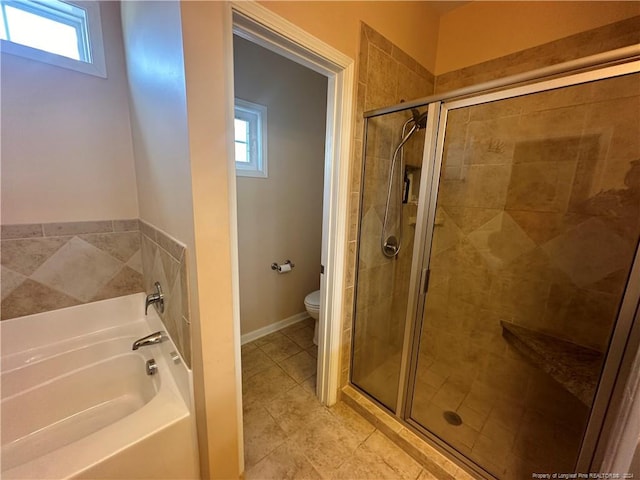 bathroom featuring a wealth of natural light, separate shower and tub, toilet, and tile patterned flooring