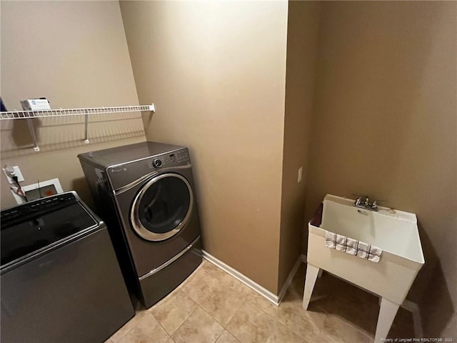 clothes washing area with independent washer and dryer and light tile patterned floors