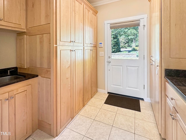 kitchen featuring sink, ornamental molding, light tile patterned flooring, and light brown cabinets