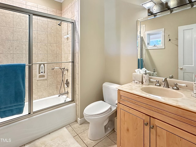 full bathroom with vanity, bath / shower combo with glass door, toilet, and tile patterned flooring