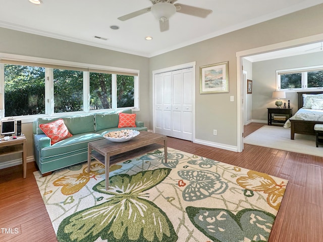 living room with crown molding, hardwood / wood-style flooring, a healthy amount of sunlight, and ceiling fan