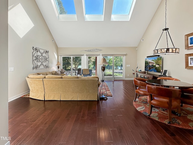 living room with high vaulted ceiling, a skylight, and dark hardwood / wood-style flooring