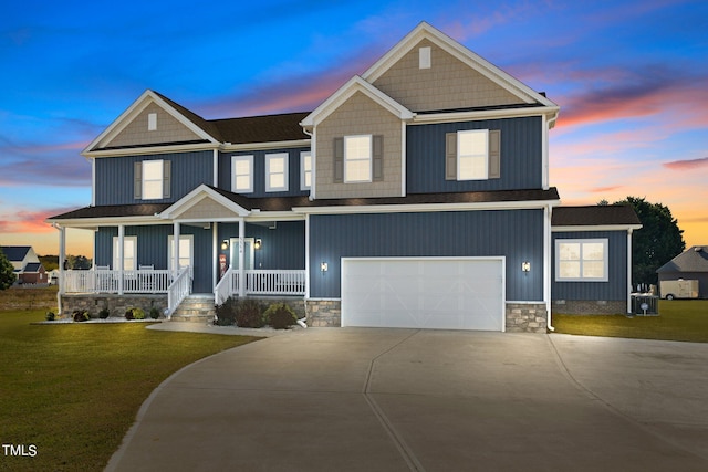 craftsman-style house featuring covered porch, a lawn, and a garage