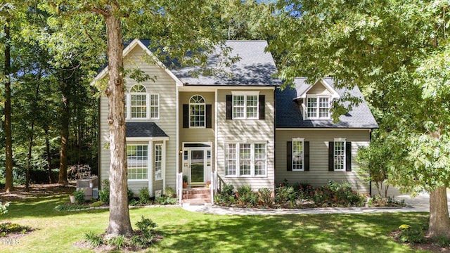 view of front of home featuring cooling unit and a front lawn