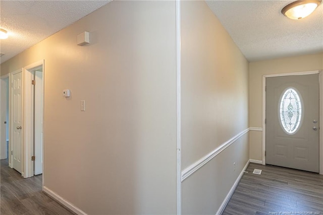 entrance foyer with dark hardwood / wood-style floors and a textured ceiling