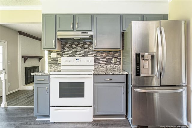 kitchen featuring light stone countertops, dark wood-type flooring, a fireplace, white electric range, and stainless steel fridge with ice dispenser