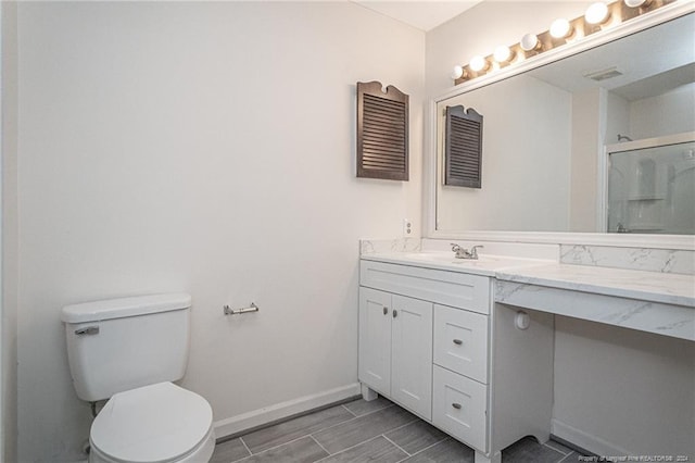 bathroom with an enclosed shower, toilet, and vanity