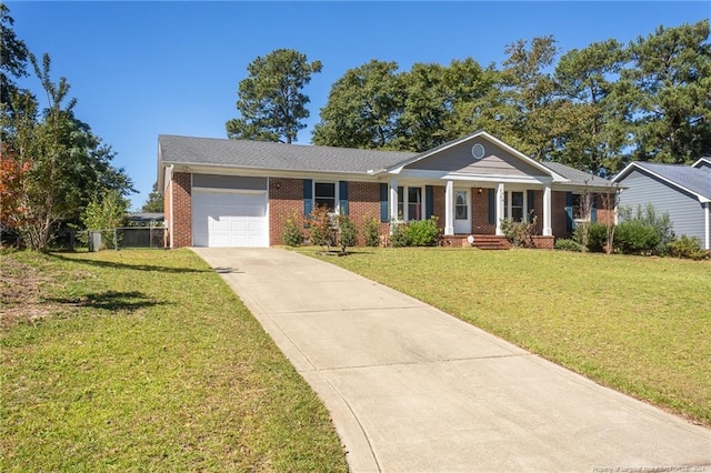 ranch-style home featuring a garage, a front yard, and covered porch