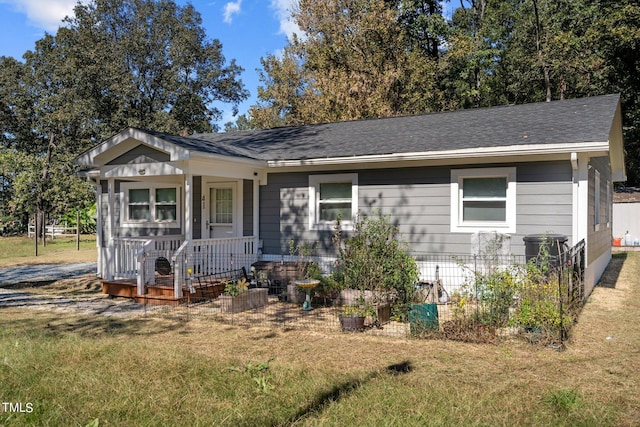 ranch-style house featuring a front yard and covered porch