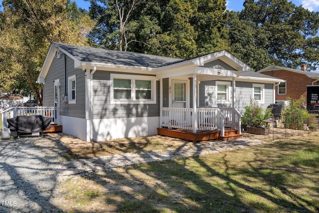 view of front facade with a wooden deck and a front lawn