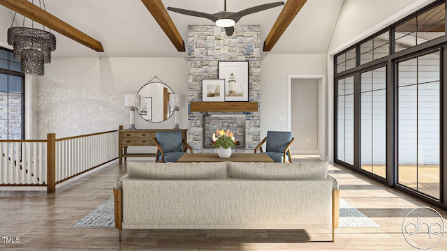 living room featuring ceiling fan with notable chandelier, a stone fireplace, vaulted ceiling with beams, and hardwood / wood-style floors