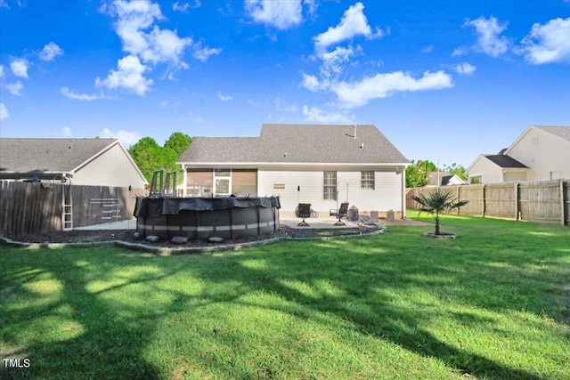 rear view of property with a fenced in pool, a fenced backyard, a yard, and a patio