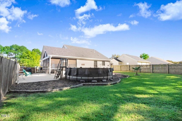 back of house featuring a lawn, a patio, a sunroom, a fenced backyard, and a pool