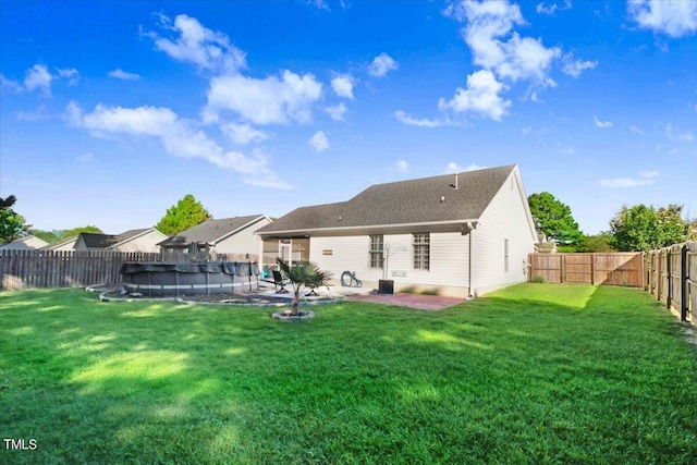 rear view of house featuring a yard, a patio, and a covered pool