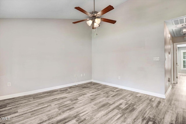 unfurnished room with attic access, visible vents, baseboards, and wood finished floors