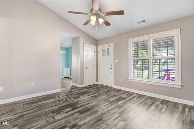 foyer featuring lofted ceiling, ceiling fan, dark wood-type flooring, visible vents, and baseboards