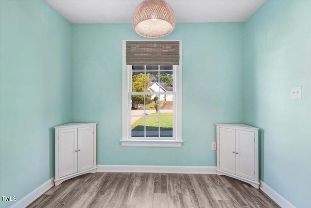 spare room with wood finished floors and baseboards