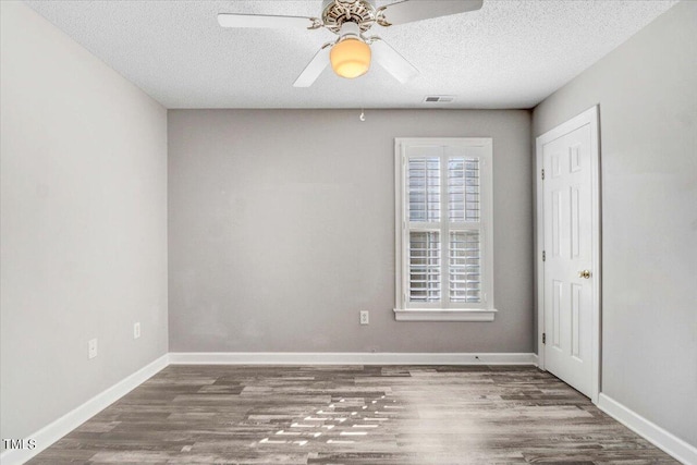 unfurnished bedroom with a textured ceiling, wood finished floors, a ceiling fan, and baseboards