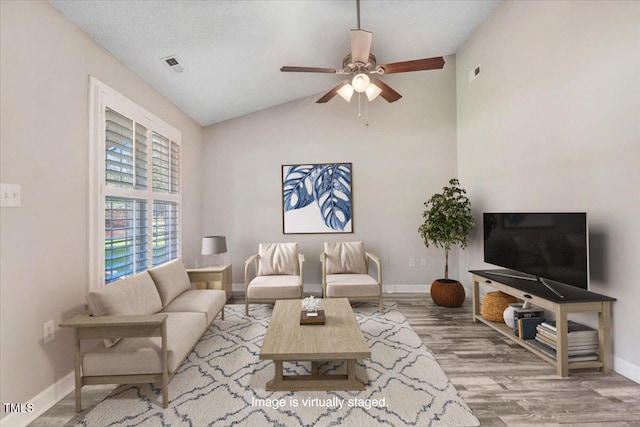 living room featuring lofted ceiling, hardwood / wood-style floors, a textured ceiling, and ceiling fan