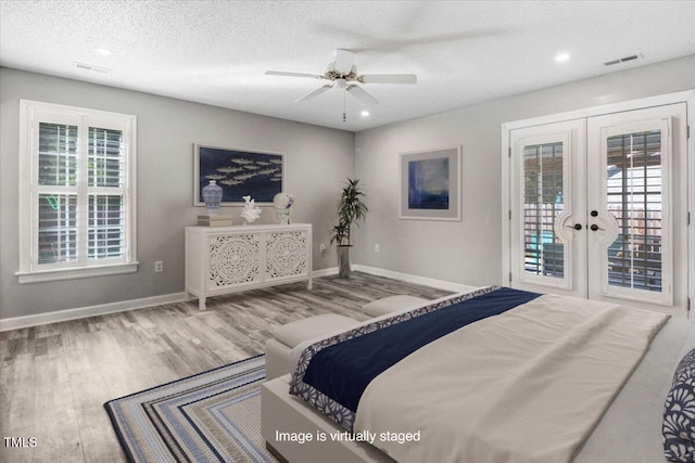 bedroom featuring wood-type flooring, access to outside, ceiling fan, a textured ceiling, and french doors