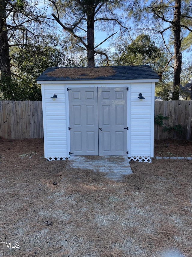 view of shed featuring fence