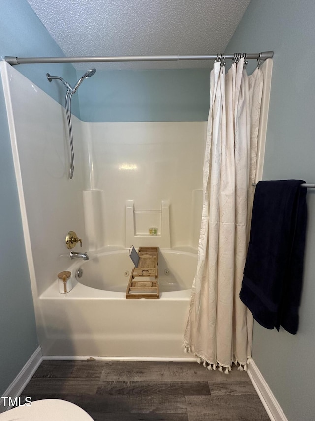 full bathroom featuring shower / tub combo with curtain, a textured ceiling, and wood finished floors