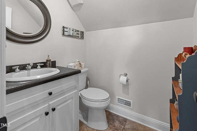 bathroom with vaulted ceiling, tile patterned floors, vanity, and toilet