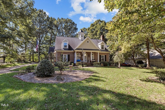 cape cod house featuring a front yard and covered porch