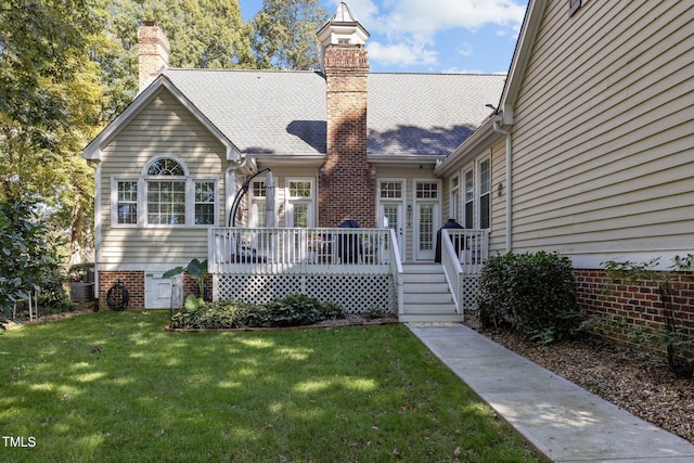 exterior space with central air condition unit, a yard, and a wooden deck