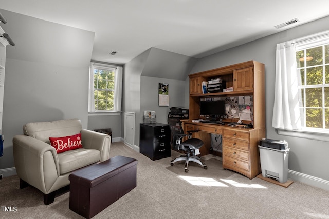 home office with lofted ceiling and light colored carpet