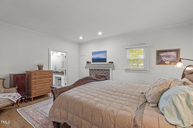 bedroom featuring crown molding, a fireplace, and wood-type flooring