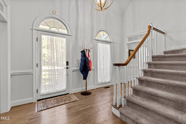 foyer entrance with a towering ceiling and hardwood / wood-style floors