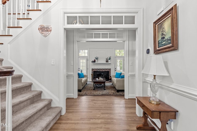 entrance foyer with wood-type flooring and a fireplace