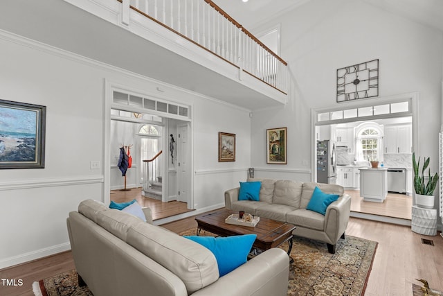 living room featuring high vaulted ceiling, a wealth of natural light, and hardwood / wood-style floors