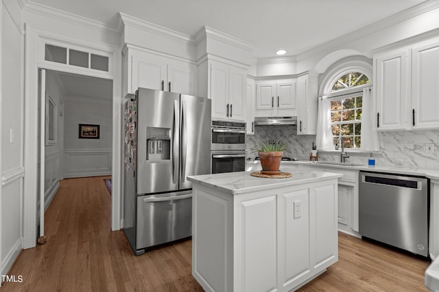 kitchen with stainless steel appliances, light hardwood / wood-style flooring, a center island, and sink