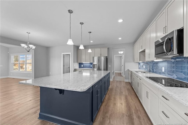 kitchen with pendant lighting, a spacious island, stainless steel appliances, and white cabinets