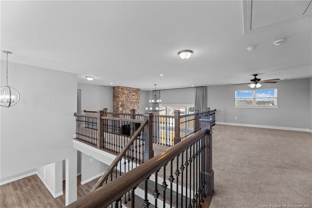 hall with an inviting chandelier and carpet floors