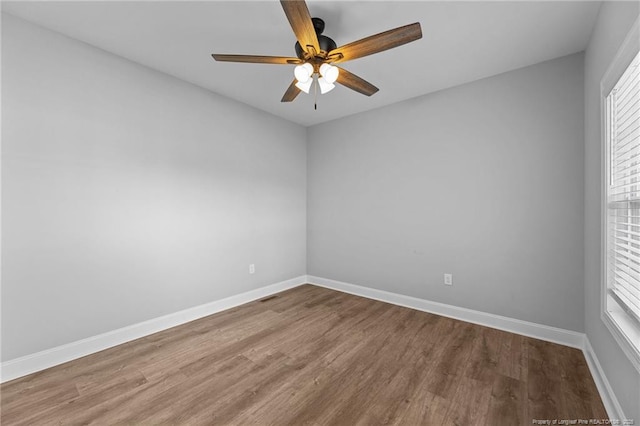 unfurnished room featuring ceiling fan, hardwood / wood-style flooring, and a healthy amount of sunlight