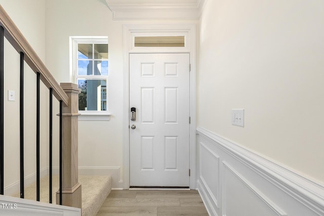 doorway to outside with light hardwood / wood-style floors and crown molding