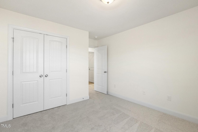 unfurnished bedroom featuring a closet and light carpet