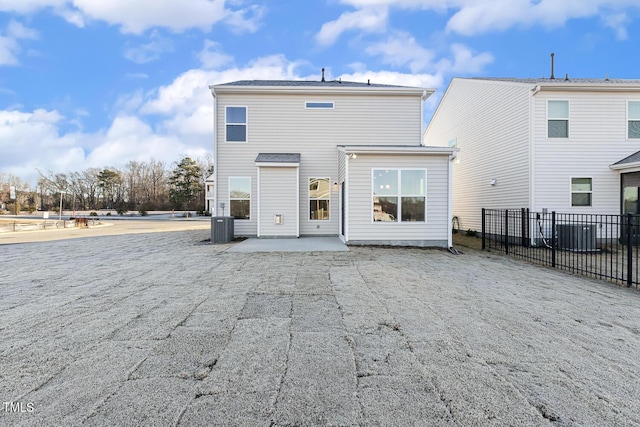 back of property with central air condition unit and a patio area