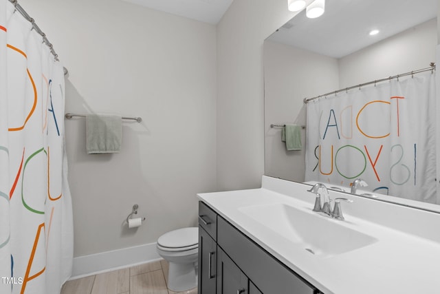 bathroom featuring a shower with shower curtain, baseboards, vanity, and toilet