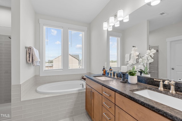 bathroom featuring a garden tub, a sink, visible vents, and double vanity