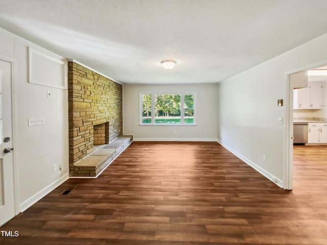 unfurnished living room featuring a textured ceiling, a fireplace, and dark hardwood / wood-style floors