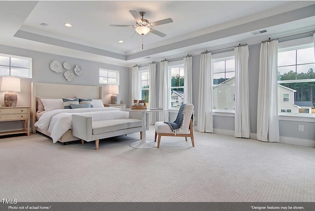 carpeted bedroom featuring ceiling fan and a tray ceiling